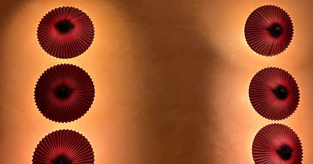 Smooth orange plaster wall with decorative circular elements showing crack-free surface that prevents plaster cracking on walls